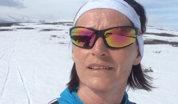 Person med solbriller i strålende sol på fjellet