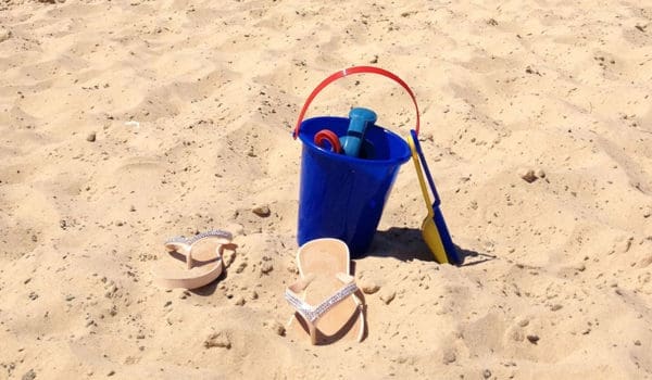 Strand med bøtte og flipflopper