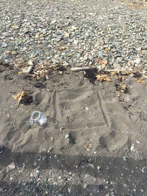 Syltetøyglass på sandstrand, Svalbard. Detalj fra sedimentprøvetaking.