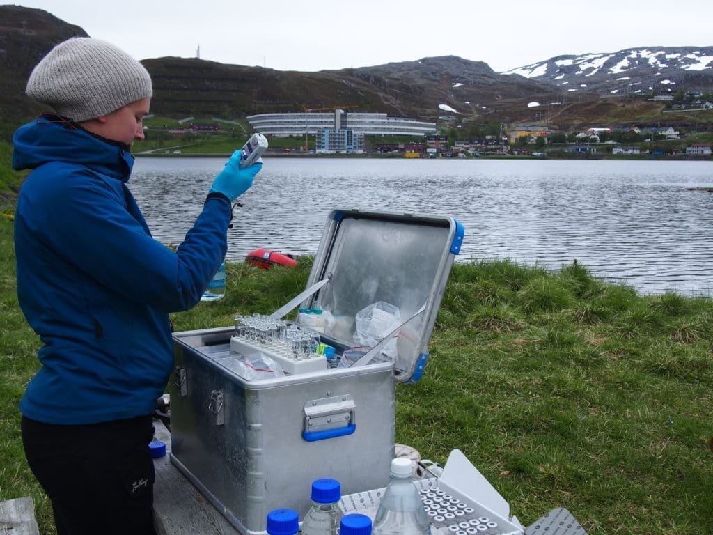 NILU-forsker Ingjerd Sunde Krogseth vannprøver ved bredden av Storvannet like ved Hammerfest.